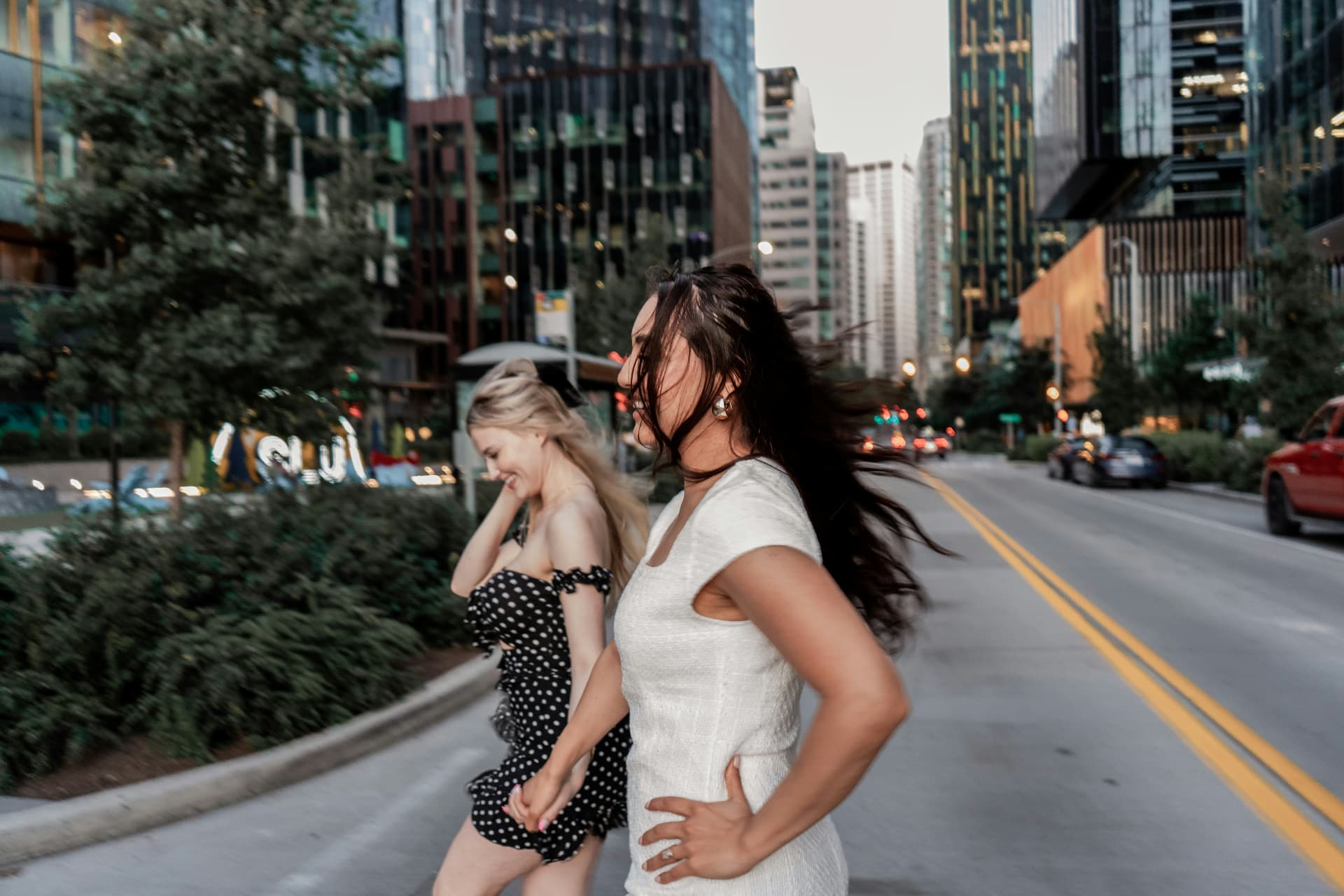 two friends laughing together on a city street